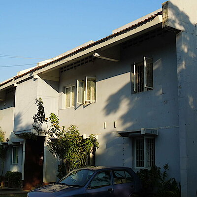 Weißes, zweistöckiges Wohnhaus mit Fenstergittern