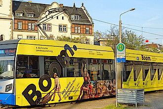 Die gelb beklebte Leipziger Boom-Straßenbahn steht am Bahnhof Plagwitz, Foto: Justin Heuer